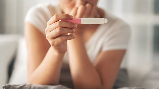 istock Young woman holding pregnancy test with negative result 2219650792