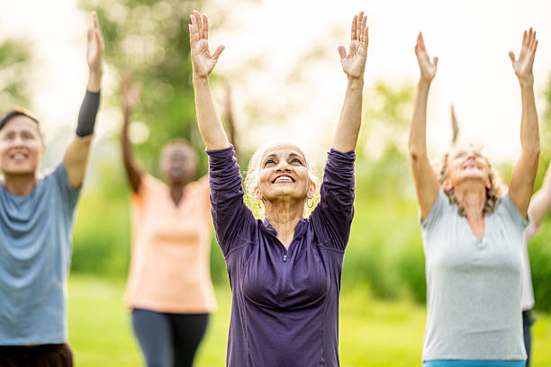 istock Senior Adults Enjoying Group Exercise Outdoors with Hands Raised 2219651407