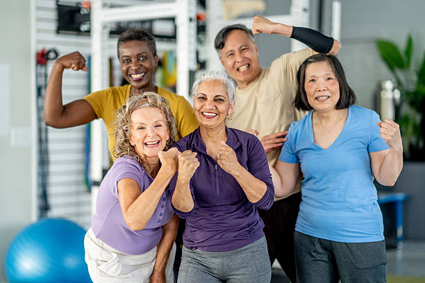 Group of Active Seniors Embracing Fitness and Smiling in Gym Environment stock photo