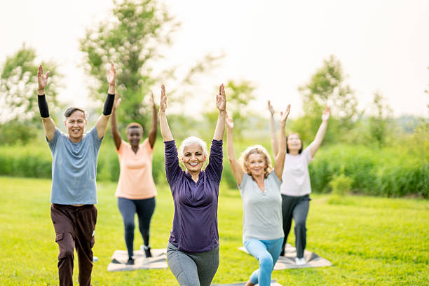 istock Group of Diverse Seniors Practicing Yoga Outdoors in a Green Park 2219652068