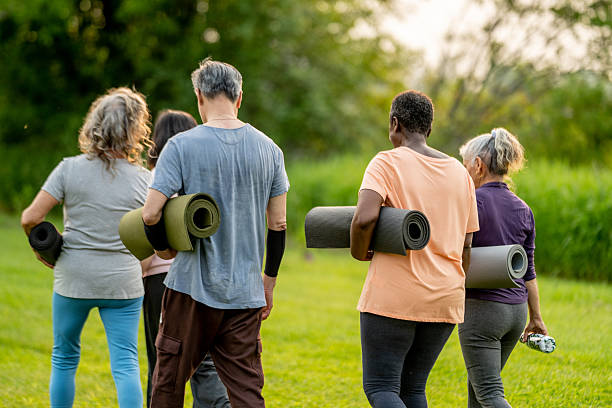 istock Group of Seniors Walking Outdoors While Carrying Yoga Mats 2219652207