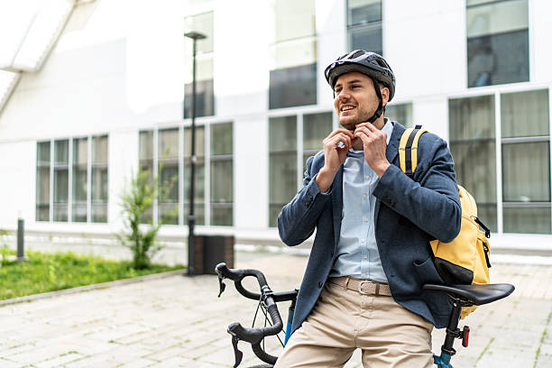 istock Businessman wearing helmet while sitting on bicycle 2219652249