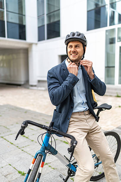 istock Businessman fastening his helmet while sitting on bicycle 2219652251