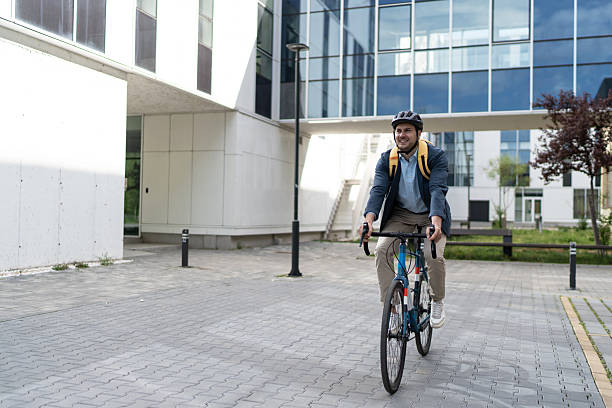 istock Businessman riding bicycle to work in urban setting 2219652450