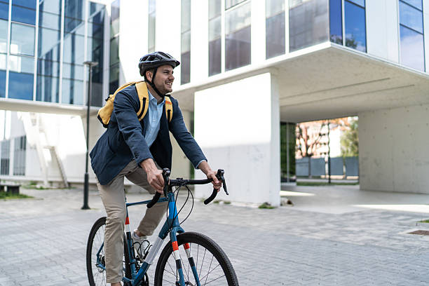 istock Businessman riding bicycle to work in modern urban setting 2219652461