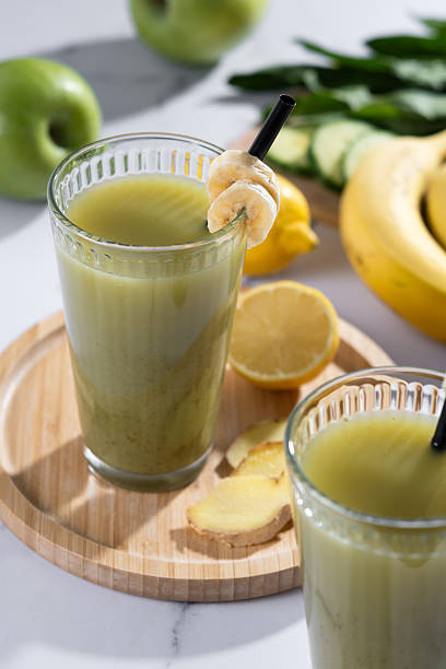 istock Green smoothie with spinach,banana, apple, and lemon on white marble 2219652502