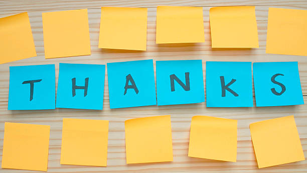 A creative thank you message formed using colorful sticky notes on a wooden background. Ideal for office, business, or customer appreciation themes.