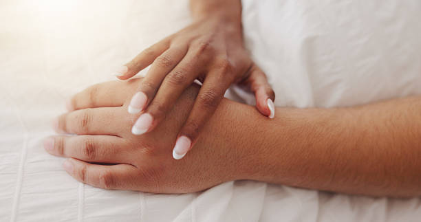 istock Hands, touch and couple relax on bed for intimacy, partner affection and connection in morning. Closeup, people and holding with cuddle for care, romance and bonding for marriage commitment at house 2219654012