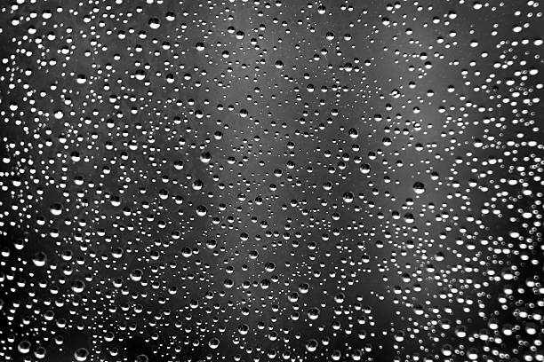 istock Monochrome texture of rain drops on window glass 2219654097