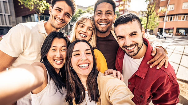 istock Multicultural cheerful friends taking selfie pic with smart mobile phone device - Youth community people laughing at camera together - Friendship concept with guys and girls having fun outdoors 2219654367