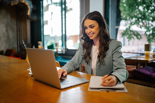 istock Dedicated Woman Typing and Smiling in Cafe 2219656143