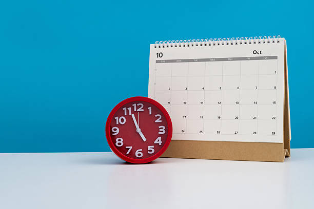 istock Calendar and alarm clock on the table 2219657265