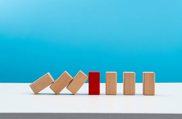 istock Red wooden block stop other falling dominos 2219658074