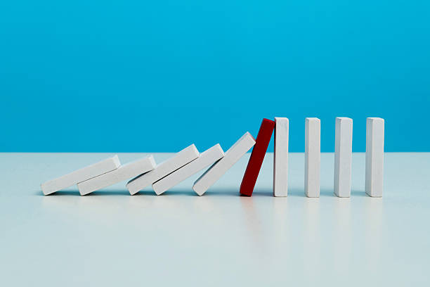 istock Red wooden block stop other falling dominos 2219658100