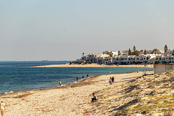 istock A sandy beach stretches toward a cityscape on a hazy horizon. 2219659835