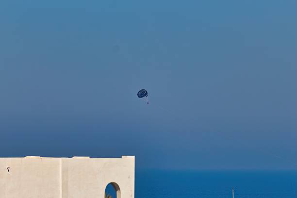 A small, dark object appears in a clear blue sky above a light-colored ledge or wall in Port El Kantoui - Sousse - Tunisia - Africa