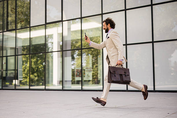 istock Modern businessman rushing to work with briefcase and phone 2219661247