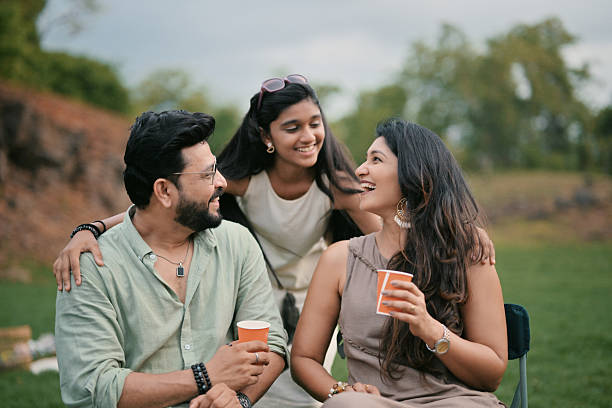 A candid moment of love and laughter as a daughter embraces her parents, capturing the essence of togetherness and joy in the serene outdoors.