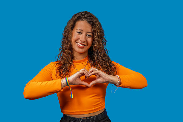 istock Young woman making heart shape with hands and smiling at camera 2219664381
