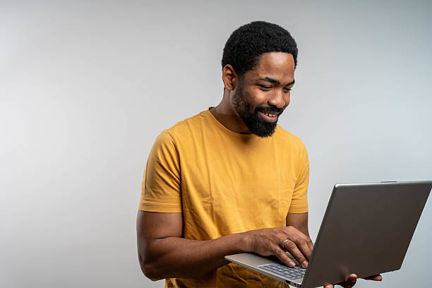istock A smiling man, working over the laptop, isolated. 2219664500