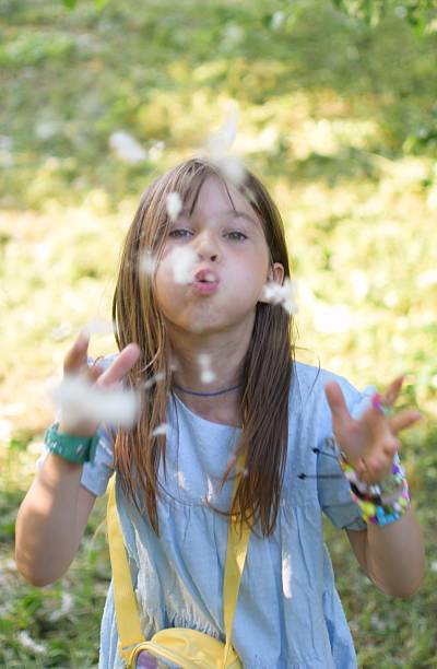 istock Beautiful girl blows poplar fluff off her hands on camera 2219665346