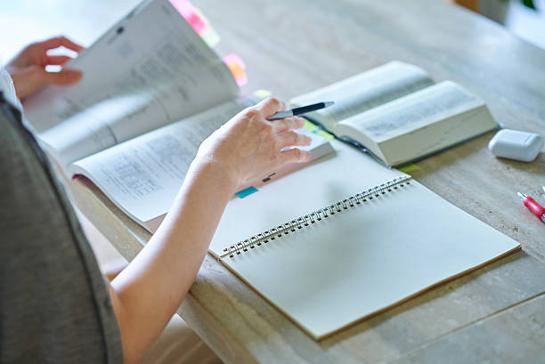 istock Hands of a woman studying with a textbook 2219666524
