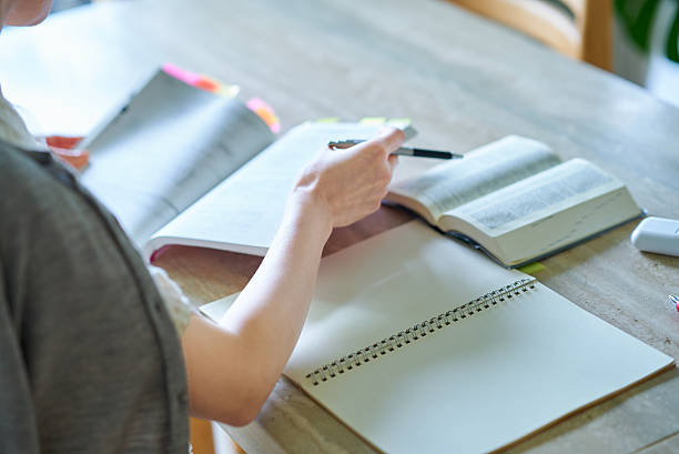 Hands of a woman studying with a textbook