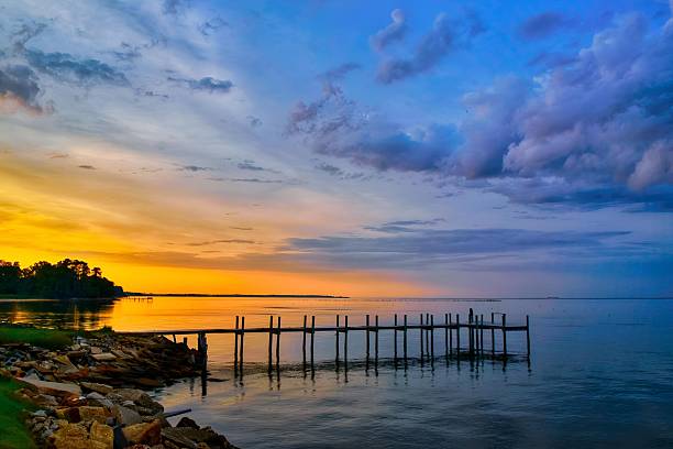 Springtime sunset and clouds over a silhouetted pier, Chesapeake Bay in southern Maryland