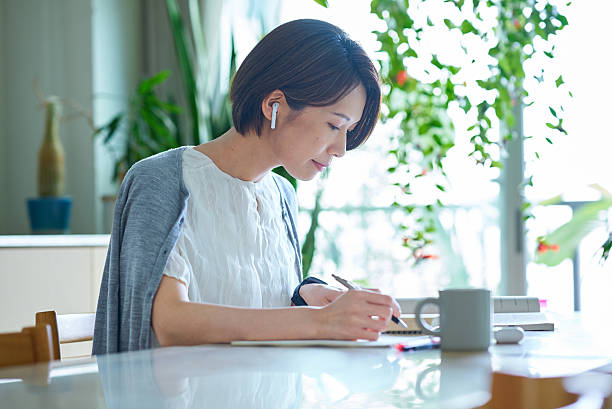 istock A woman studying with earphones 2219666906