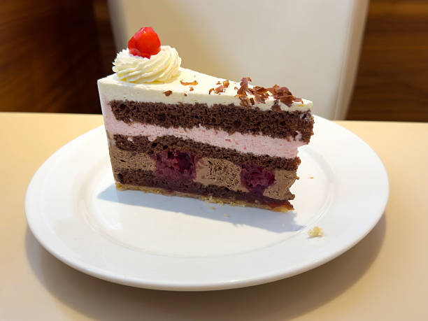 istock Slice of black forest cake with cream and cherry on plate 2219668696
