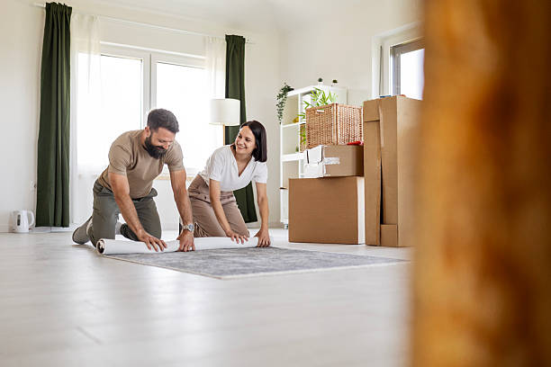istock Excited Couple Settling In by Laying Down Carpet 2219669655