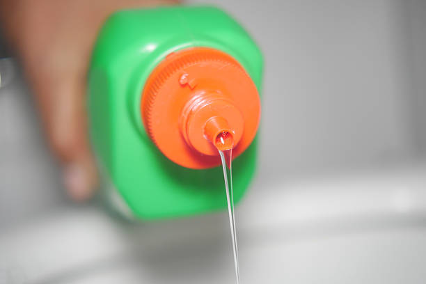 Liquid flows from a green bottle into a sink during cleaning.