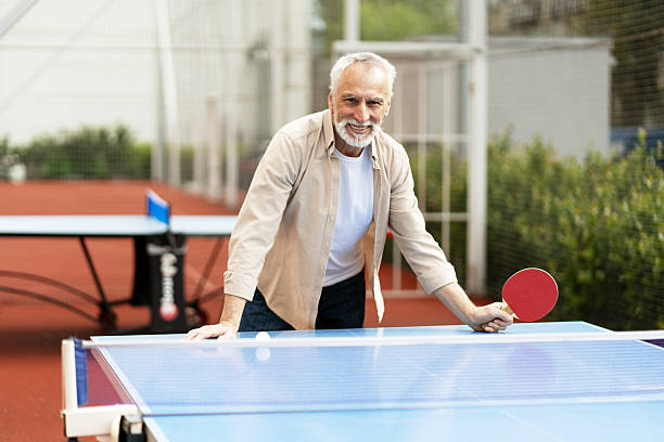 istock Senior man playing ping pong outdoors, embracing active lifestyle 2219673128