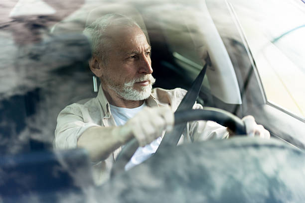 istock Senior man driving modern car safely wearing seatbelt 2219673152