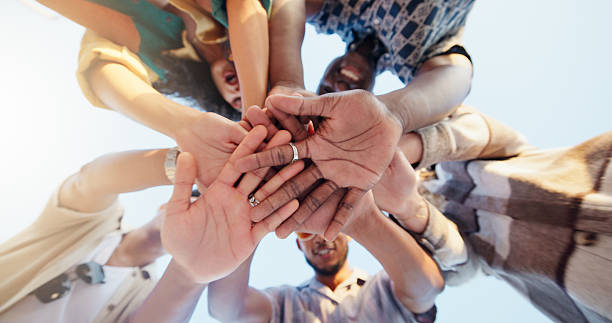 istock Hands stack, low angle and group of friends outdoor with community, collaboration or support. Circle, bonding and people with palms together for solidarity, goals or target in huddle from below. 2219674106