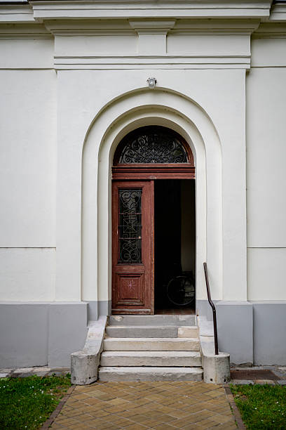 istock Old arched doorway with partially open wooden door 2219676400