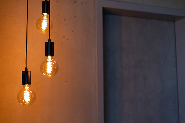 istock Three stylish pendant lights emit a warm glow in a contemporary setting. The soft illumination highlights the minimalist design of the space, creating a cozy atmosphere 2219676670