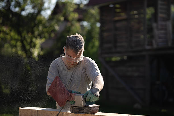 istock Carpenter sanding wood with belt sander in outdoor workshop 2219676672