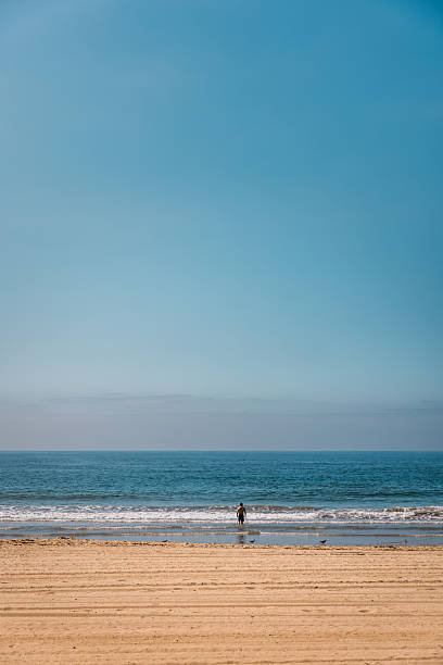 istock Solitary Man in the Pacific Ocean on a Sunny Day 2219677665