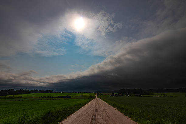 WEATHER - Dramatic black rain clouds over fields and country road. 20