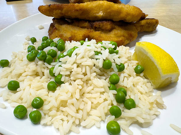 Fried chicken with rice, peas, and lemon wedge, lifestyle