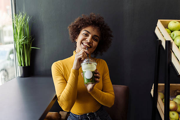 istock Young beauty woman drinking smoothie at cafeteria 2219684231