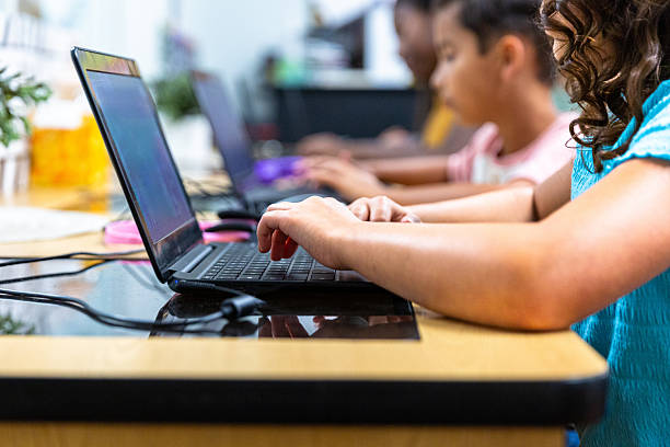 Elementary Students learning in the computer lab with their teacher stock photo