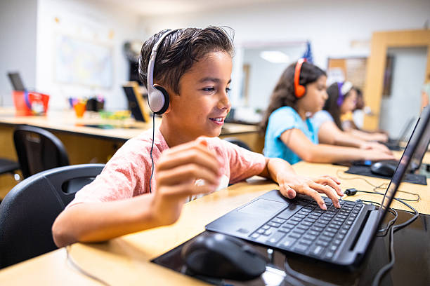 Elementary Students learning in the computer lab with their teacher stock photo