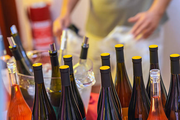 istock Assorted wine bottles with yellow caps arranged on ice bucket stand at public event. Concept of cold wine tasting, organized bar, social gathering, party 2219691128