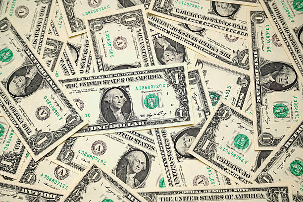 istock Multiple one-dollar bills scattered across a flat surface, showcasing American currency 2219691137