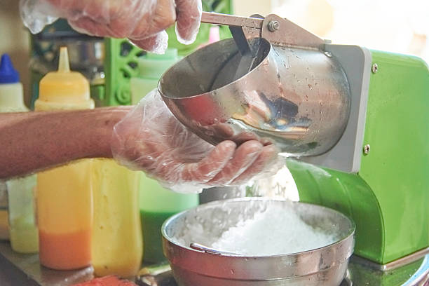 istock Person using an ice crusher machine to make a raspado, cool Colombian snack 2219693072
