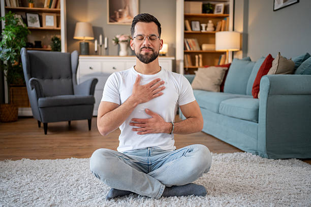 istock Young adult man practicing meditation at home for mindfulness and wellbeing 2219695635
