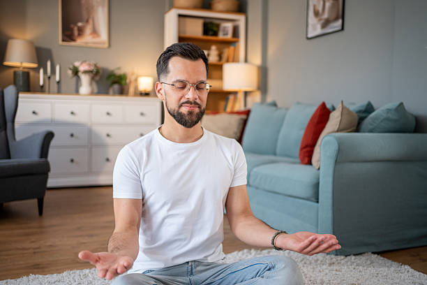 istock Young man meditating in living room, finding inner peace and mindfulness 2219695639