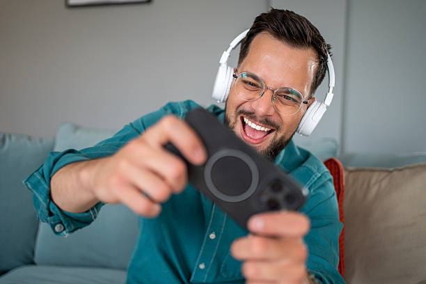 istock Excited gamer winning a mobile game on the couch at home 2219696009